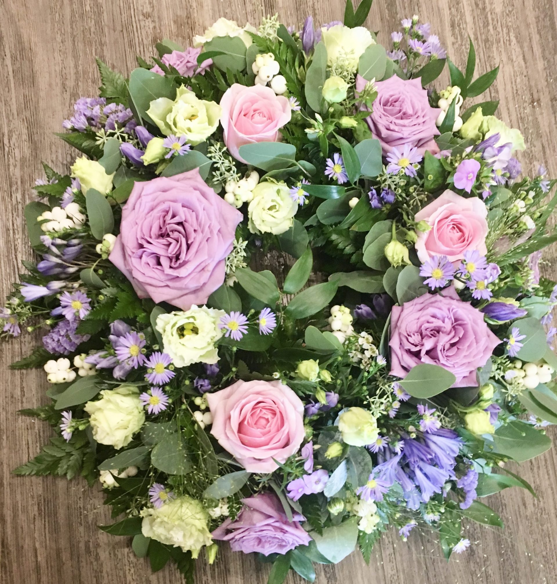 This beautiful lilac and white wreath, symbolising peace and serenity. This elegant arrangement combines lush blue blooms with pure white flowers, offering a heartfelt tribute of respect and remembrance. Perfect for expressing condolences and bringing comfort during a time of loss. Each wreath is carefully crafted to ensure it reflects both beauty and grace during this difficult time.
