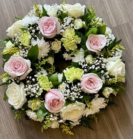 This beautiful lime and white wreath, symbolising peace and serenity. This elegant arrangement combines lush blue blooms with pure white flowers, offering a heartfelt tribute of respect and remembrance. Perfect for expressing condolences and bringing comfort during a time of loss. Each wreath is carefully crafted to ensure it reflects both beauty and grace during this difficult time.