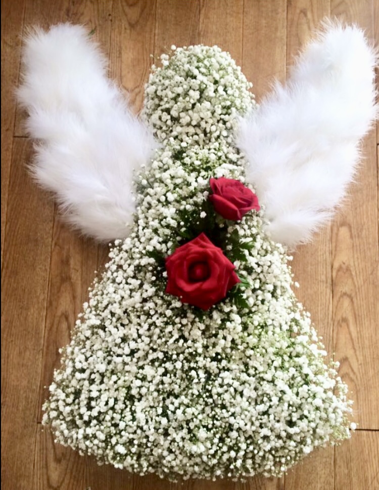 A lovely massed angel in white with touches of feathers and glitter on the flowers Colour of you choice 24hrs notice required Due to seasonal variations some items may be substituted to produce a display of equal quality and value. Professionally arranged by our expert florists with care. Delivered by hand by our own driver. Click & collect is also available