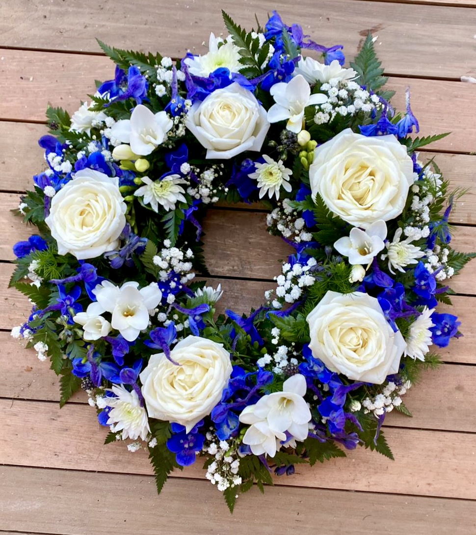 This beautiful blue and white wreath, symbolising peace and serenity. This elegant arrangement combines lush blue blooms with pure white flowers, offering a heartfelt tribute of respect and remembrance. Perfect for expressing condolences and bringing comfort during a time of loss. Each wreath is carefully crafted to ensure it reflects both beauty and grace during this difficult time.